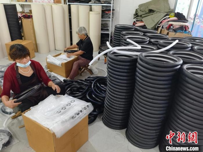 圖為村民在汽車飾品企業(yè)生產(chǎn)車間中工作?！巫雍?攝