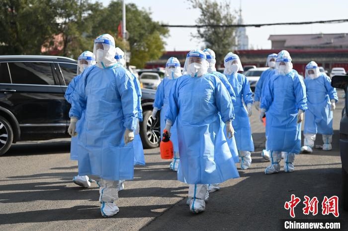 圖為醫(yī)務人員在封閉小區(qū)做防控工作?！⑽娜A 攝