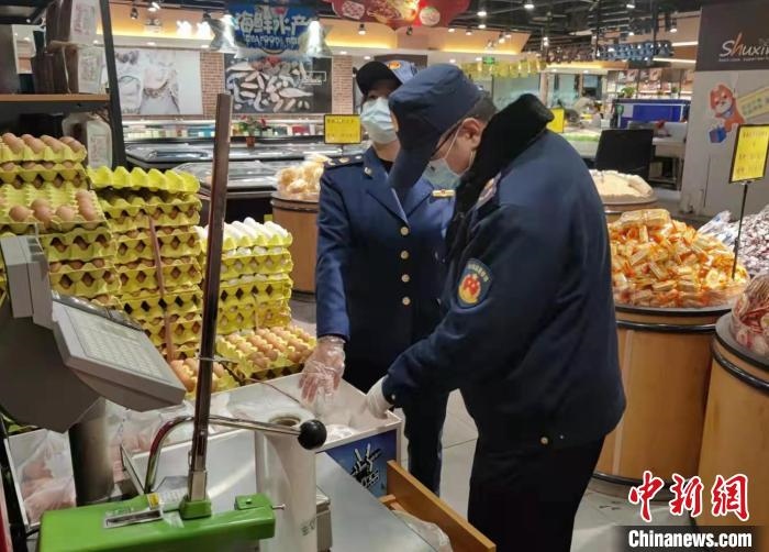 圖為疫情期間，甘肅嘉峪關(guān)市場監(jiān)管局工作人員檢查蔬菜市場?！?柴佳楠 　攝
