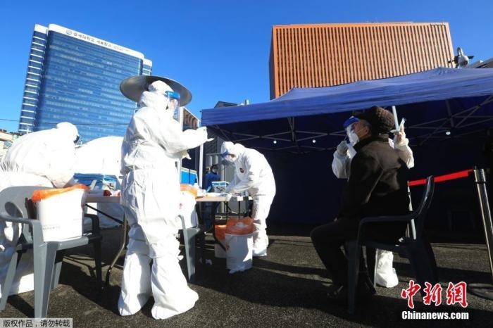 資料圖：韓國首爾，醫(yī)務(wù)人員對市民進(jìn)行新冠病毒檢測。