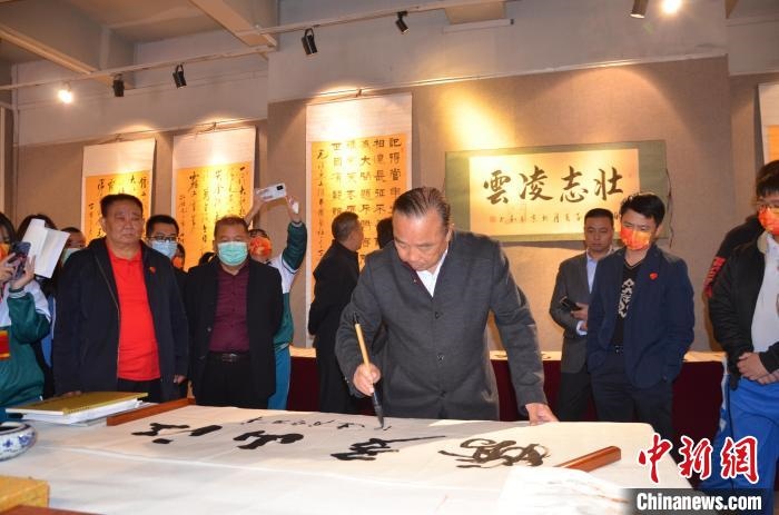 圖為“鐵軍老戰(zhàn)士”、著名書法家、解放軍報(bào)原副總編輯連俊義少將現(xiàn)場揮毫?！☆佇玛?攝 攝