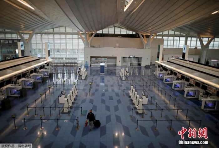 資料圖：日本東京，東京國際機場，一名乘客在國際航班航站樓的登機區(qū)。