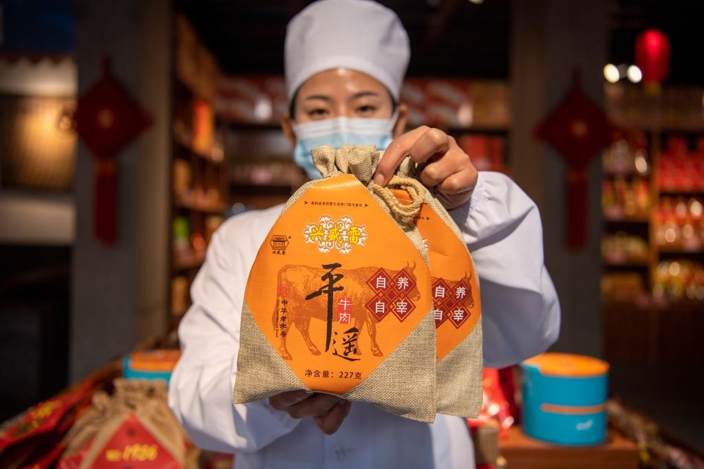 1月27日，在平遙古城南大街的一家平遙牛肉店內(nèi)，工作人員展示一款牛肉產(chǎn)品。新華社記者 楊晨光 攝