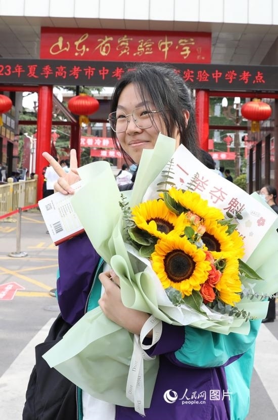 6月7日高考首日，山東67萬考生走進(jìn)考場，拼搏逐夢。在山東省實(shí)驗(yàn)中學(xué)考點(diǎn)，考生進(jìn)考場前手捧向日葵花拍照留念，寓意“一舉奪魁”。人民網(wǎng)記者 劉祺攝