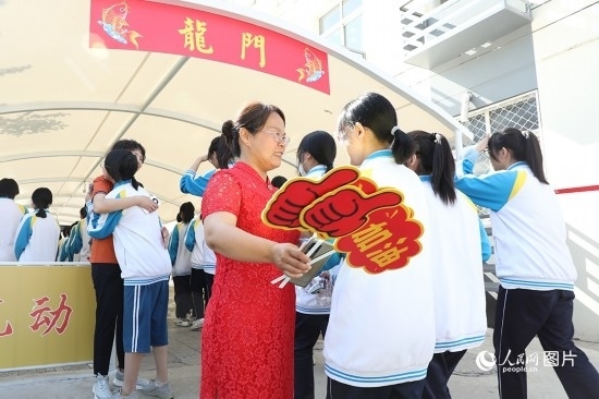 6月7日一早，雄安新區(qū)安新中學(xué)老師在給同學(xué)們加油鼓勁兒。人民網(wǎng) 李兆民攝