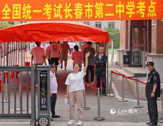 6月7日，在長春市第二中學(xué)考點(diǎn)，一名考生信心滿滿進(jìn)入考場，并與家長揮手致意。人民網(wǎng)記者 李洋攝
