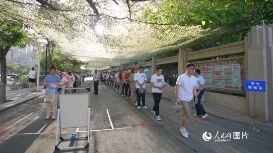 6月7日，烏魯木齊市第七十中學(xué)門口，考生們有序進(jìn)入考場。人民網(wǎng) 李欣洋攝