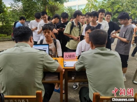 專武干部在發(fā)放兵役登記證。韋碩 攝