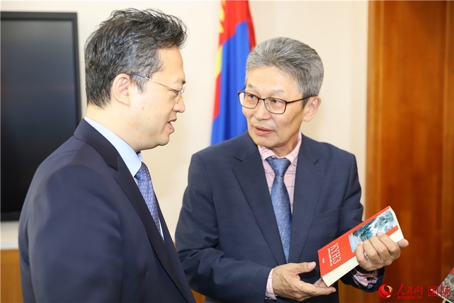 其米德策耶（右一）向李峙介紹翻譯成果。人民網記者 霍文攝