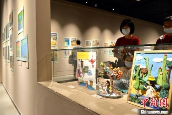 圖為家長帶著孩子參觀展覽。呂明 攝