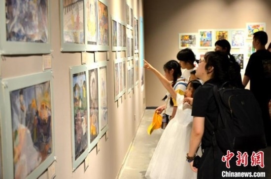 圖為家長帶著孩子參觀展覽。呂明 攝