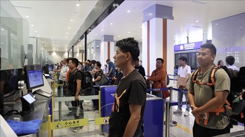 6月13日，乘坐中老鐵路國際旅客列車的旅客在磨憨邊檢大廳排隊(duì)候檢。李揚(yáng) 攝