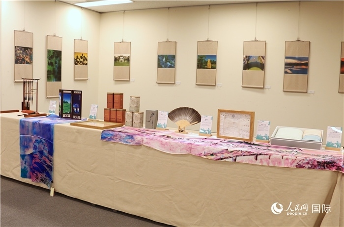 現(xiàn)場(chǎng)展出的馮學(xué)敏攝影作品與湖州市特色工藝品。（人民網(wǎng) 許可攝）
