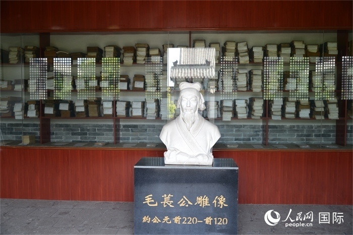 河間詩(shī)經(jīng)齋毛萇雕像。雕像后書(shū)櫥中陳列的是歷代各版本《詩(shī)經(jīng)》及譯本。 人民網(wǎng) 趙昭攝