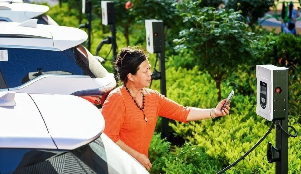 2023年5月24日，山東省膠州市新立街小區(qū)內(nèi)一位居民使用電動(dòng)汽車充電樁掃碼充電。該小區(qū)加裝各類智慧設(shè)備，打造“智慧社區(qū)”，為居民生活帶來便利。