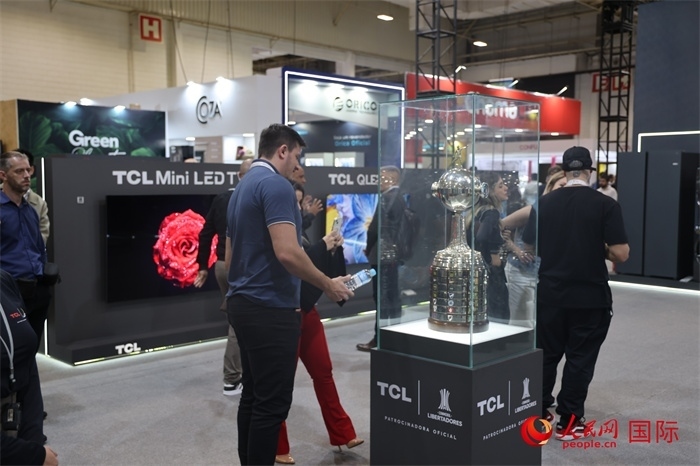參觀者在TCL展臺前觀看南美解放者杯獎杯，據(jù)介紹，TCL是南美解放者杯（2023—2026賽季）全球官方合作伙伴。（人民網(wǎng)記者 時元皓攝）