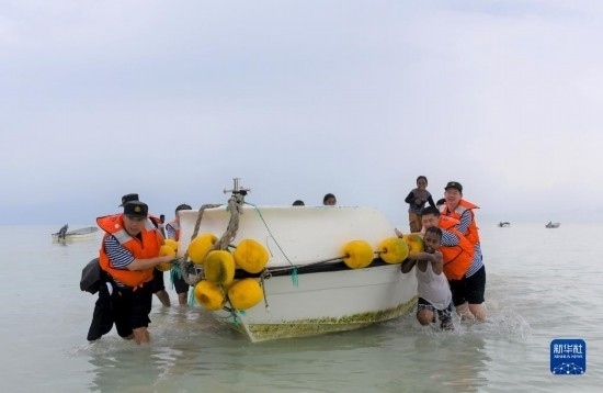 7月21日，中國海軍“和平方舟”號醫(yī)院船醫(yī)護(hù)人員涉水登島，前往基里巴斯一診療點(diǎn)。新華社記者 黎云 攝