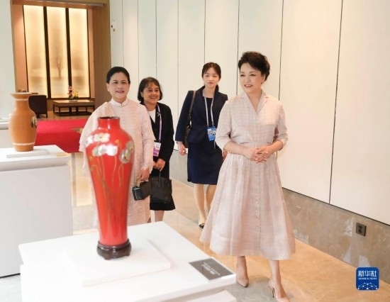 7月27日下午，國家主席習(xí)近平夫人彭麗媛在四川成都會見陪同印度尼西亞總統(tǒng)佐科來華出席第31屆世界大學(xué)生夏季運動會開幕式并訪華的總統(tǒng)夫人伊莉亞娜。這是彭麗媛和伊莉亞娜欣賞成都特色非遺工藝品。新華社記者 丁林 攝