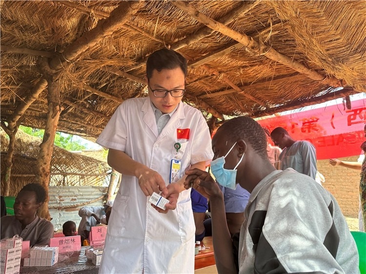 圖為南昌大學第一附屬醫(yī)院病理科主治醫(yī)師張振東為村民解說藥品使用方法。中國駐乍得醫(yī)療隊供圖