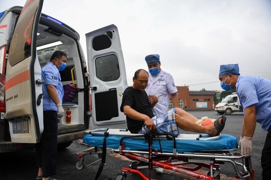 8月1日，在北京市門頭溝區(qū)妙峰山鎮(zhèn)妙峰山民族學(xué)校臨時(shí)安置點(diǎn)，北京急救中心工作人員在轉(zhuǎn)運(yùn)一名受傷村民。新華社記者 鞠煥宗 攝