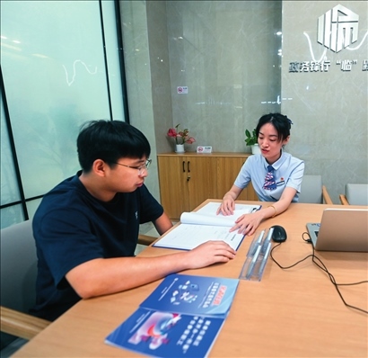 在杭州市臨安區(qū)政務(wù)服務(wù)中心的“為企服務(wù)中心”，黨員志愿者（右）解答企業(yè)主的疑問(wèn)（2023年7月7日攝）。徐昱攝/本刊