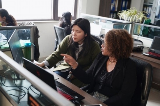 梅德哈妮（右）與中國同事討論設(shè)計方案。受訪對象供圖