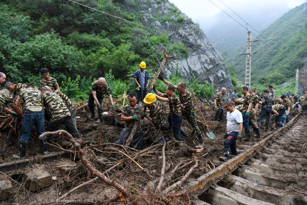8月1日，在北京市門頭溝區(qū)水峪嘴村附近一段被阻斷的鐵路線上，中鐵六局工作人員在清理軌道上的雜物，全力恢復交通。新華社記者 鞠煥宗 攝
