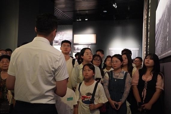 （講解員為記者團(tuán)同學(xué)們講述歷史。北京舞蹈學(xué)院 全峻汐攝