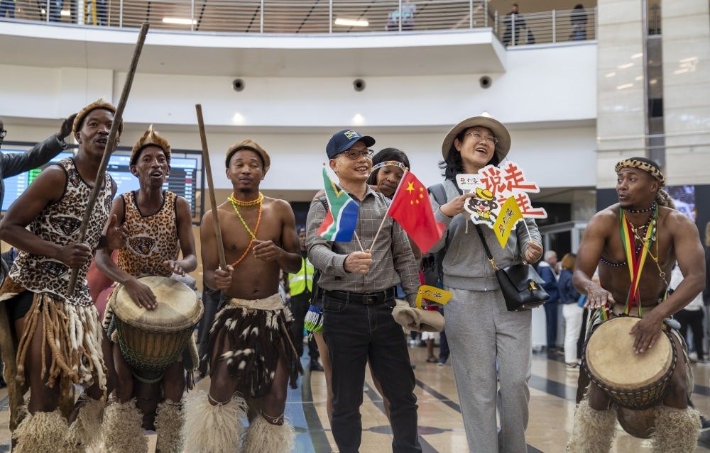在南非約翰內(nèi)斯堡坦博國際機場，南非舞蹈演員歡迎中國試點恢復出境團隊旅游后首批抵達南非的中國游客（2023年3月29日攝）。