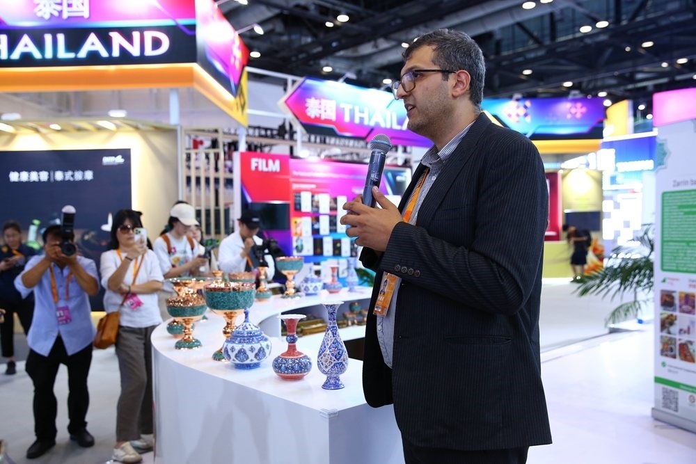 9月1日，參展商在國家會議中心向媒體記者介紹展臺信息。新華社記者 孫瑋彤 攝