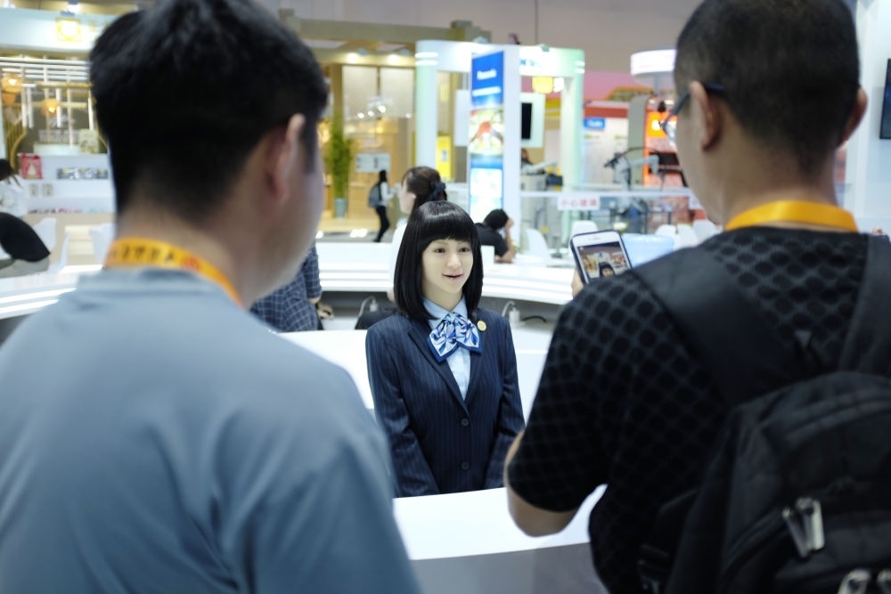 9月1日，媒體記者在國家會議中心與服務(wù)機(jī)器人互動。新華社記者 劉夢琪 攝