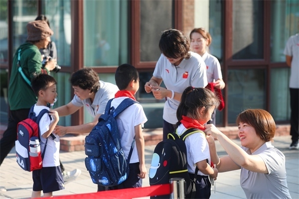 8月30日，雄安史家胡同小學學生體驗學校生活。老師為學生佩戴?；铡? /></p> <p style=