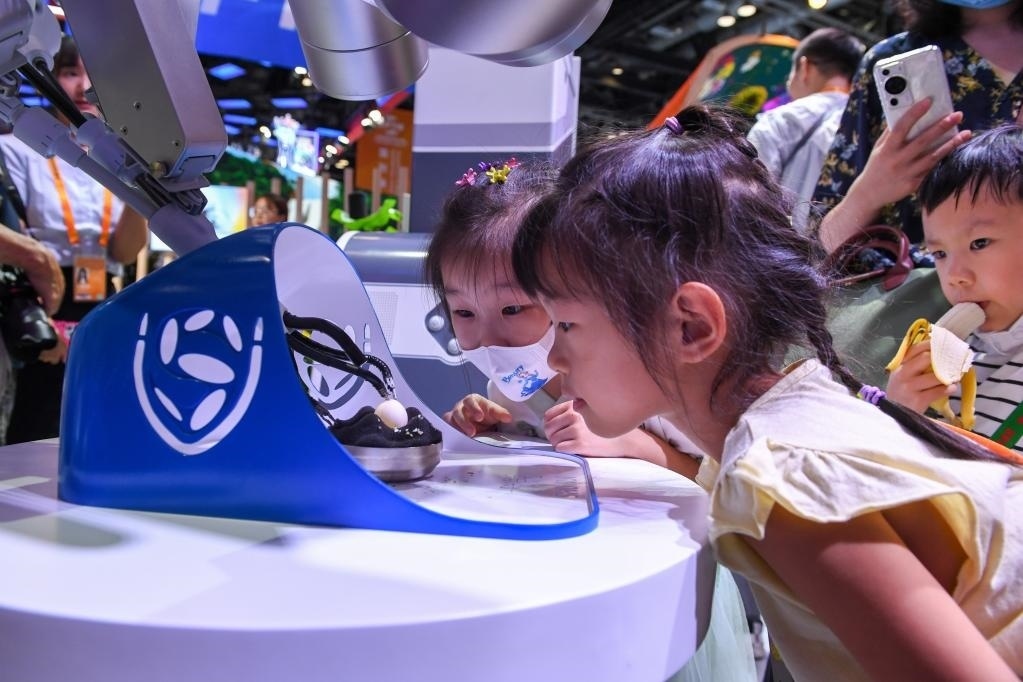 9月3日，幾名小朋友在國(guó)家會(huì)議中心觀看單孔腔鏡手術(shù)機(jī)器人展示。新華社記者 鞠煥宗 攝