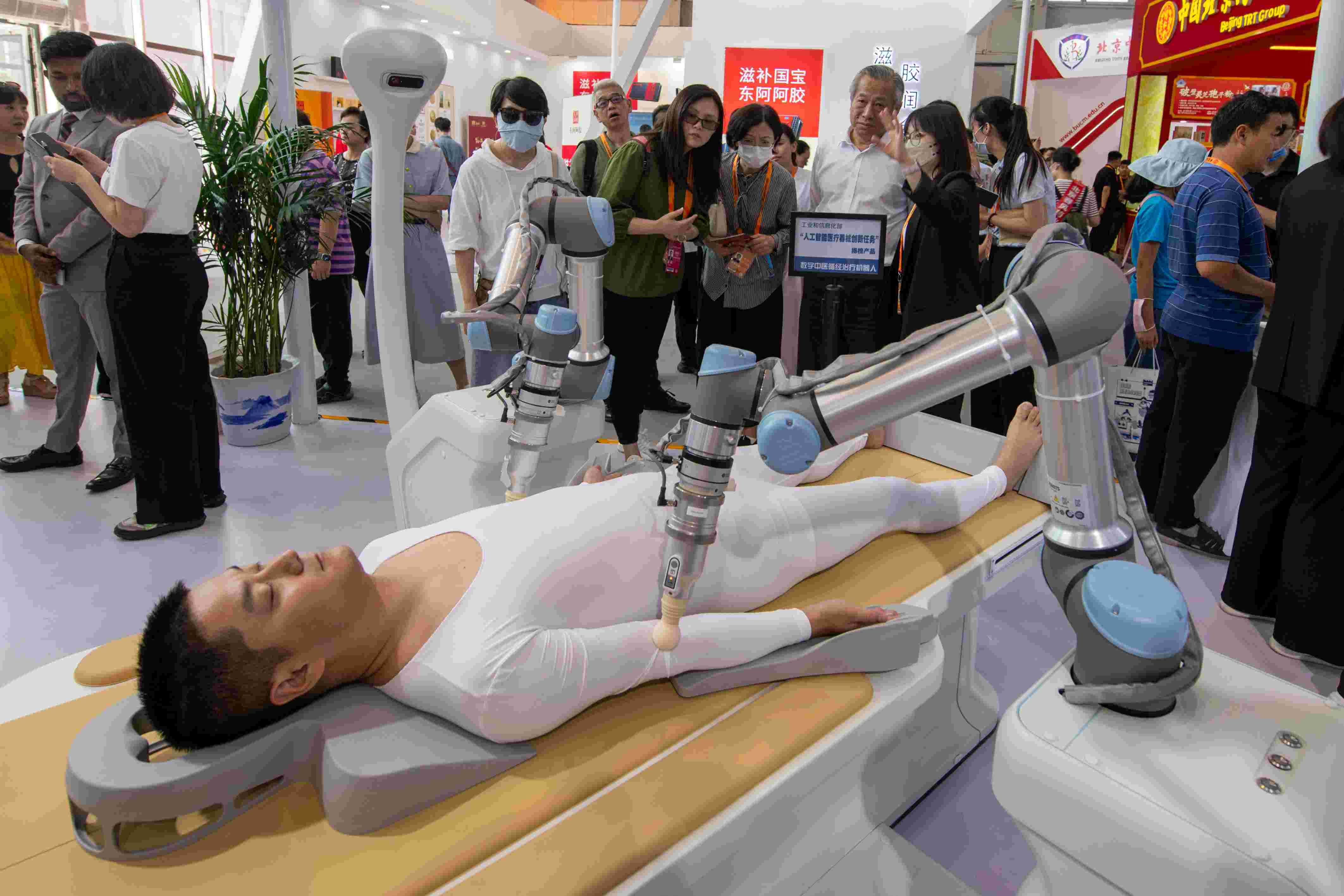 在位于首鋼園的健康衛(wèi)生服務展區(qū)，觀眾正在參觀數(shù)字中醫(yī)循經(jīng)治療機器人。人民網(wǎng)記者 翁奇羽攝