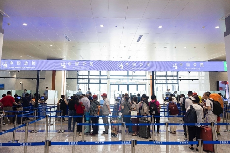 乘坐中老鐵路國際旅客列車的旅客在磨憨邊檢大廳排隊候檢。黃遠飛 攝