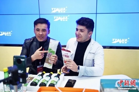 2023年3月，甘肅省慶陽市環(huán)縣電商創(chuàng)業(yè)孵化基地內(nèi)，來自蘭州文理學(xué)院的塔吉克斯坦留學(xué)生正在協(xié)助主播直播帶貨當(dāng)?shù)剞r(nóng)特產(chǎn)品。李亞龍 攝