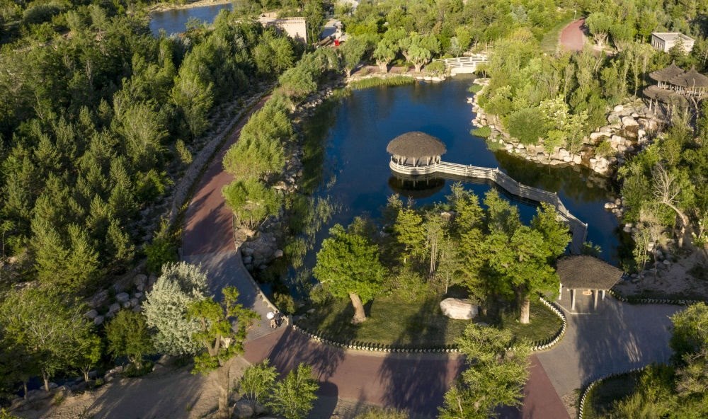 坐落在寧夏銀川市賀蘭山腳下的賀蘭山運動休閑公園（2021年5月27日攝，無人機(jī)照片）。這里曾是一片砂石采礦塌陷區(qū)，當(dāng)?shù)赝ㄟ^植被景觀再造、水系建設(shè)、現(xiàn)代管網(wǎng)鋪建等手段，重新利用廢石、廢坑及各類廢棄建筑材料，把這里變成一座免費開放的主題公園。新華社記者 馮開華 攝