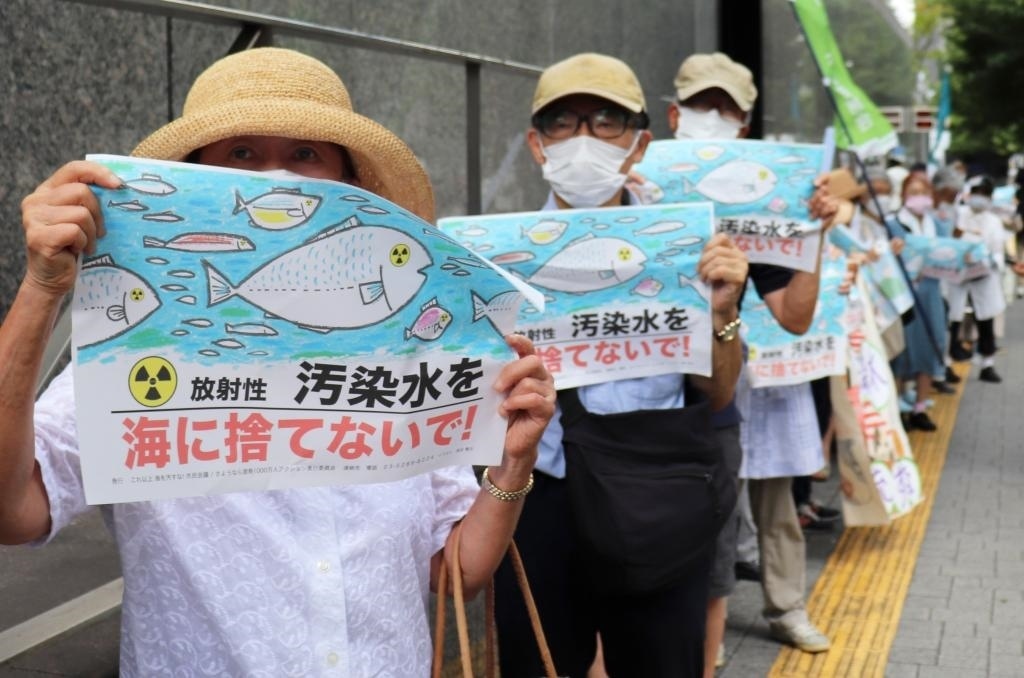 8月24日，日本民眾手持“不要將污染水扔進大?！钡葮苏Z在東京電力公司總部前集會，抗議日本政府和東電公司無視民意啟動核污染水排海。新華社記者楊光攝