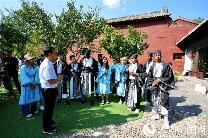 圖為選手們聽導(dǎo)游講解。人民網(wǎng) 盧鵬宇攝