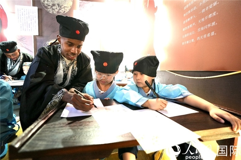 圖為選手與同學(xué)們一起寫書法。人民網(wǎng) 盧鵬宇攝