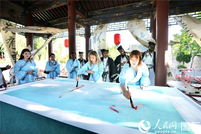 選手們提筆書寫“家園”二字。人民網(wǎng) 盧鵬宇攝