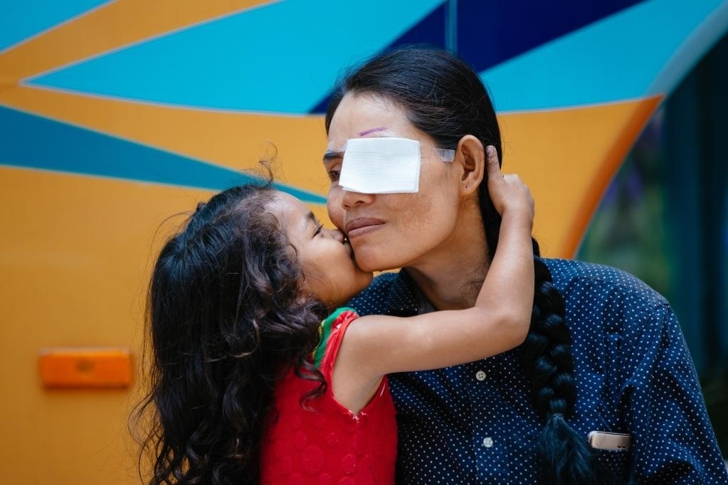 2019年3月15日，在柬埔寨磅湛省醫(yī)院，即將接受白內(nèi)障手術(shù)的患者孫美樂(lè)接受女兒的親吻祝福。在接受了中國(guó)醫(yī)療隊(duì)的白內(nèi)障義診手術(shù)后，她的視力逐步恢復(fù)，生活有了新的光明和希望。