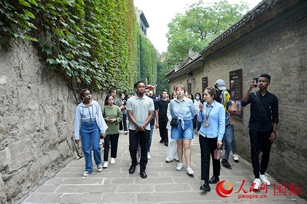 選手們認(rèn)真聆聽導(dǎo)游講解。人民網(wǎng) 盧鵬宇攝