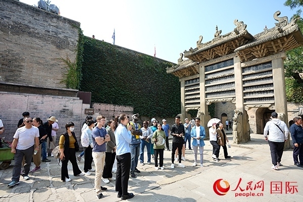 選手們認(rèn)真聆聽導(dǎo)游講解。人民網(wǎng) 盧鵬宇攝