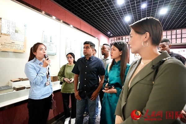 選手們認(rèn)真聆聽導(dǎo)游講解。人民網(wǎng) 盧鵬宇攝