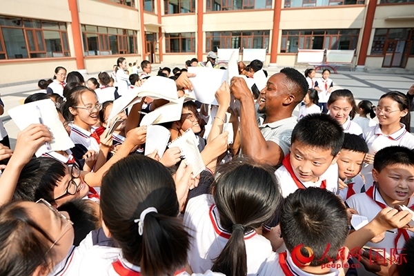 孩子們和選手互動簽名。人民網(wǎng) 盧鵬宇攝