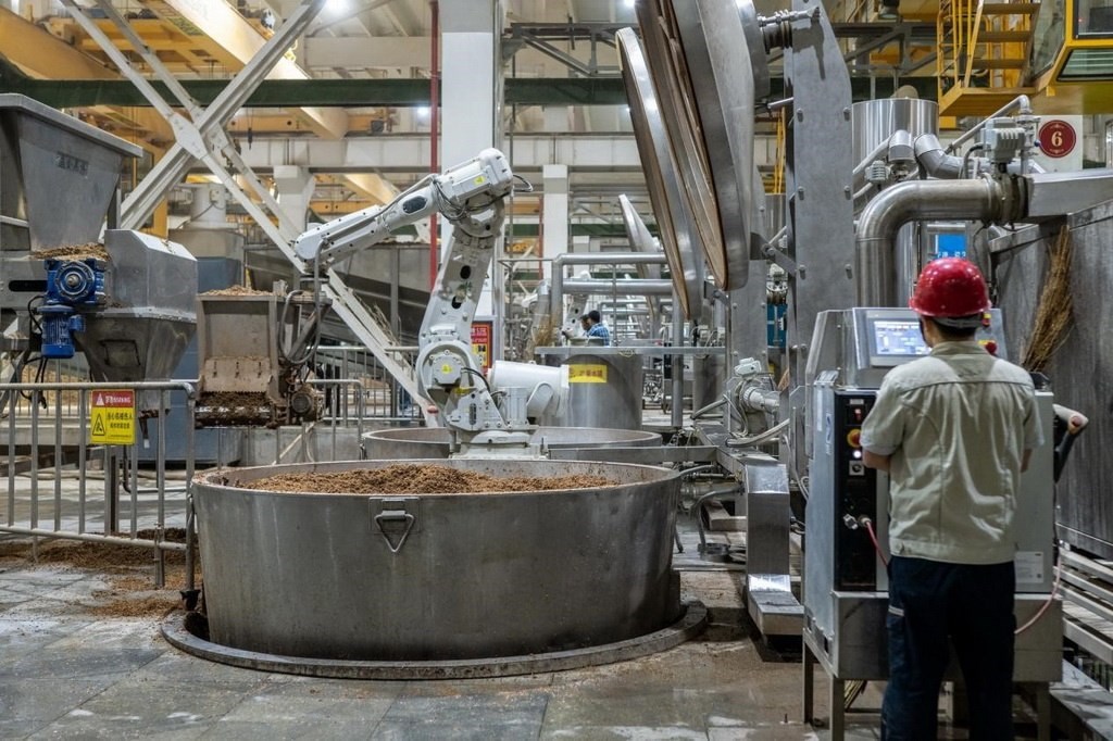 907車間里，機(jī)械臂正在撒料裝甑。嚴(yán)磊攝