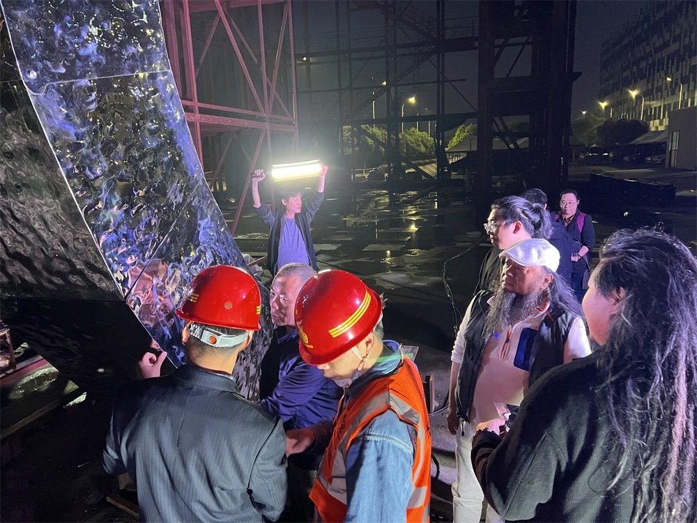 林崗（右二）和團隊查看主火炬制作進(jìn)度。受訪者供圖