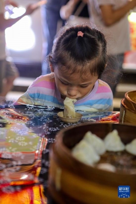 9月27日，小朋友在南翔小籠長街宴上品嘗南翔小籠。