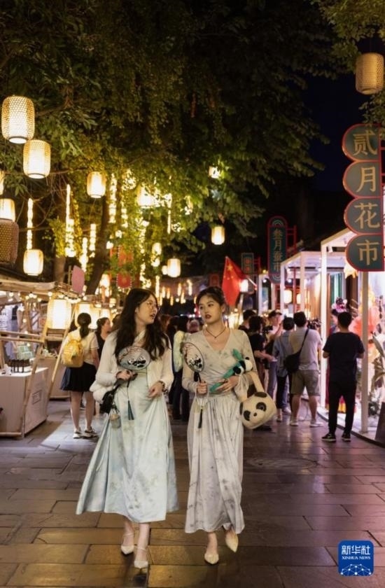 在成都寬窄巷子，兩位來(lái)自安徽的游客在新“十二月市”街區(qū)游覽（9月29日攝）。